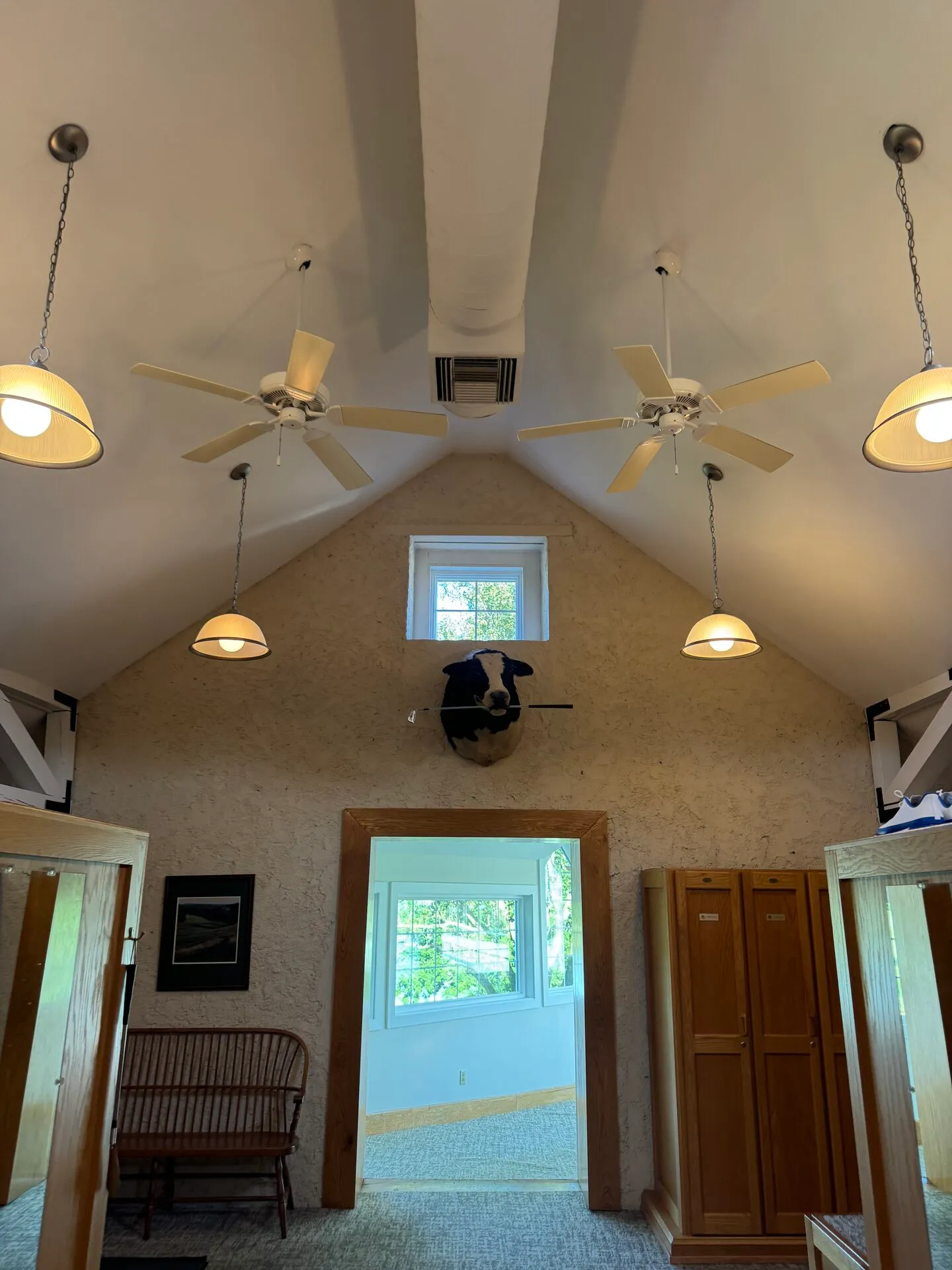 Inside the converted stone barn at Stonewall, the vaulted ceiling rising above a mounted cow head and warm pendant lights