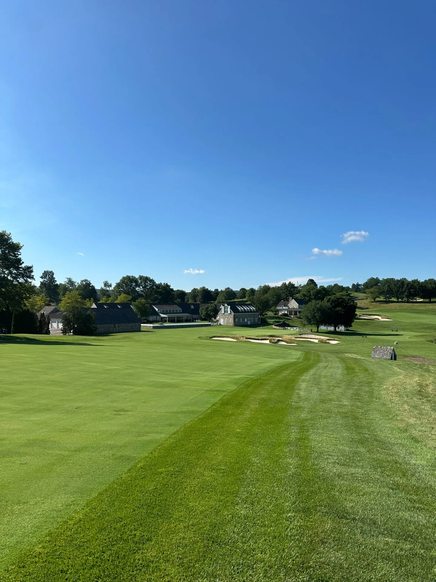 The 18th at Stonewall, the fairway sweeping down toward the stone clubhouse buildings and bunkers