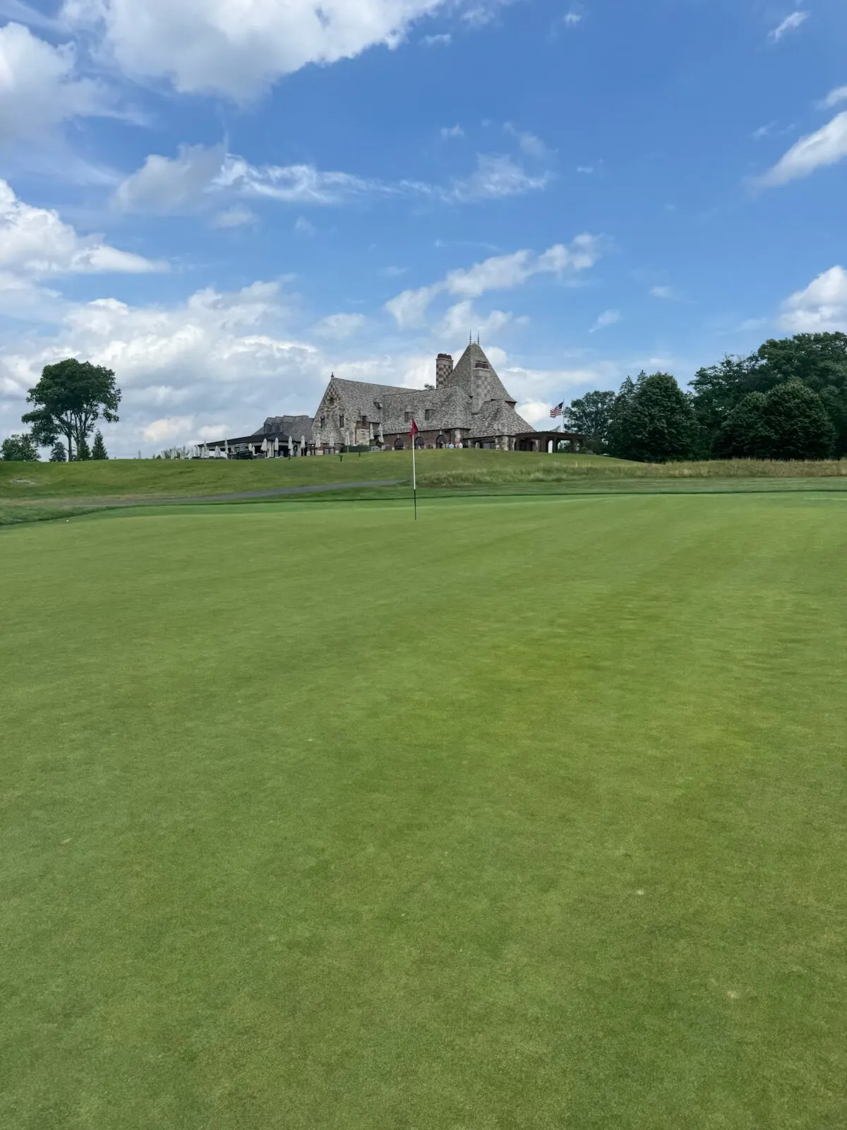 Looking from the green toward the Mountain Ridge clubhouse perched above, the pin and American flag framing the view