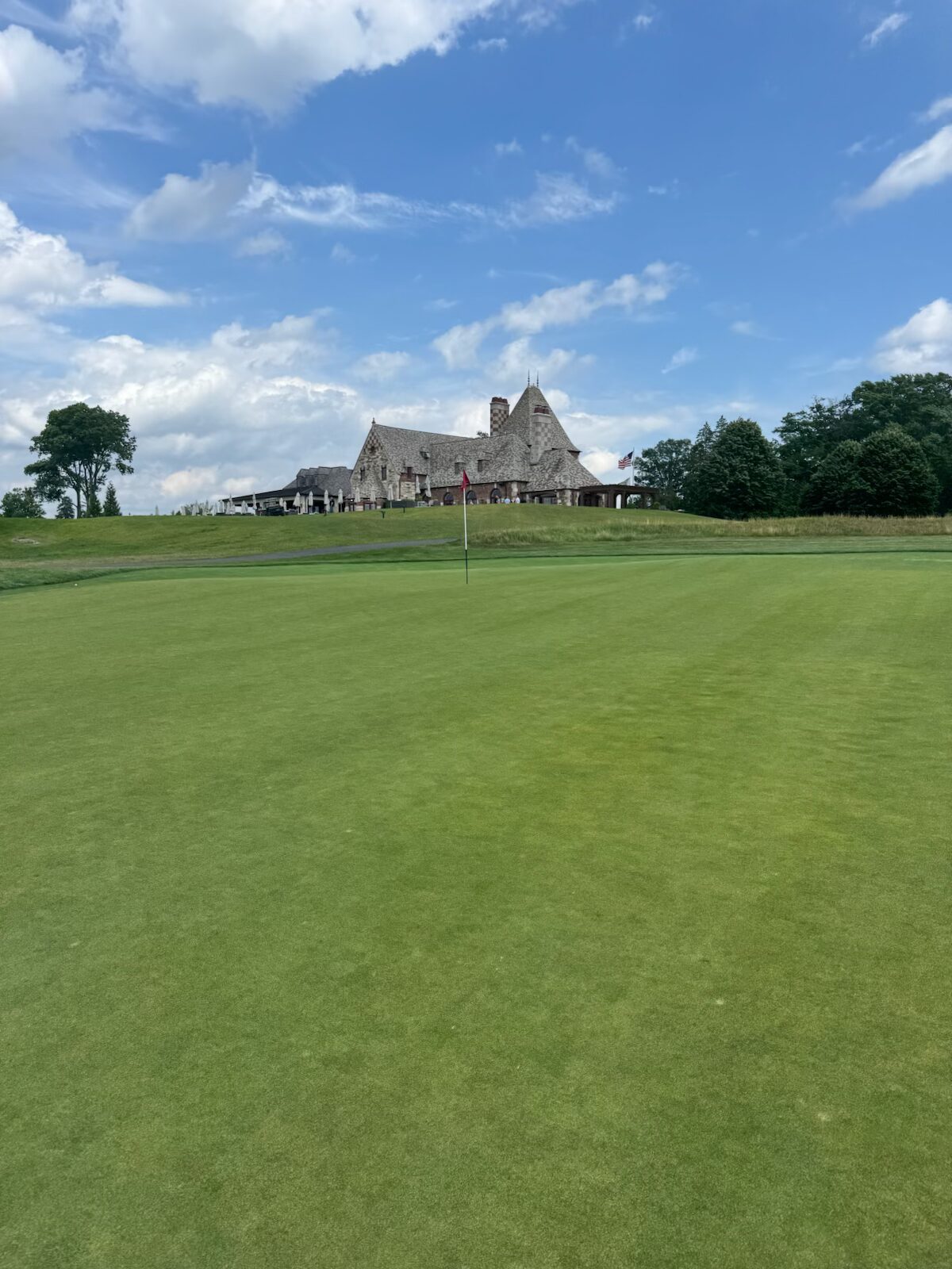 Looking from the green toward the Mountain Ridge clubhouse perched above, the pin and American flag framing the view