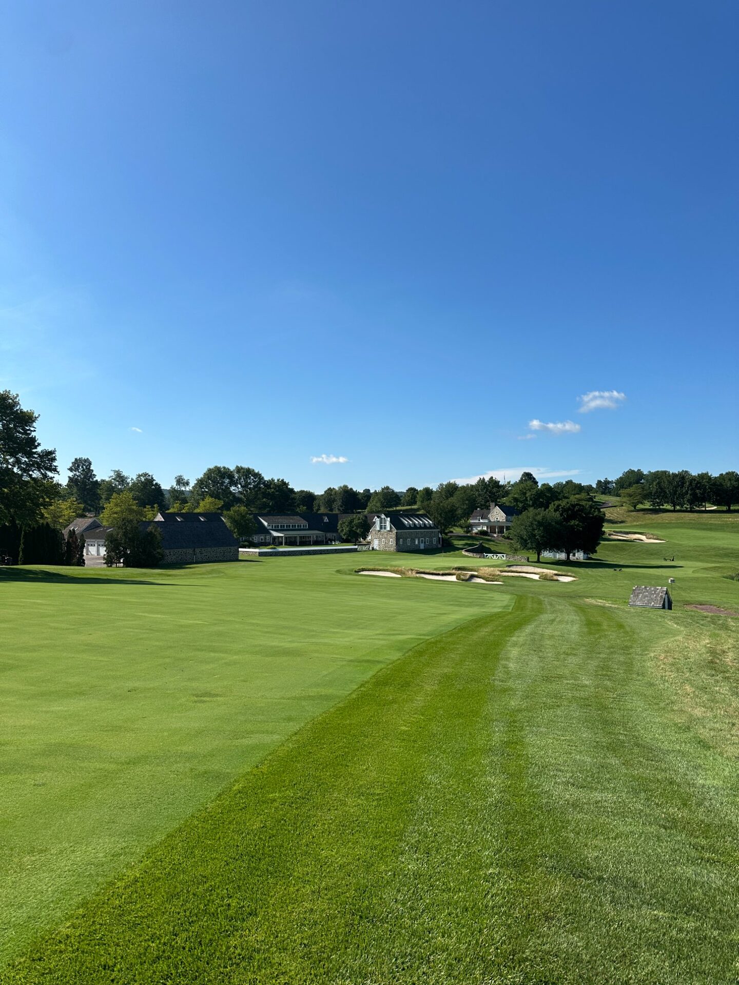 The 18th at Stonewall, the fairway sweeping down toward the stone clubhouse buildings and bunkers